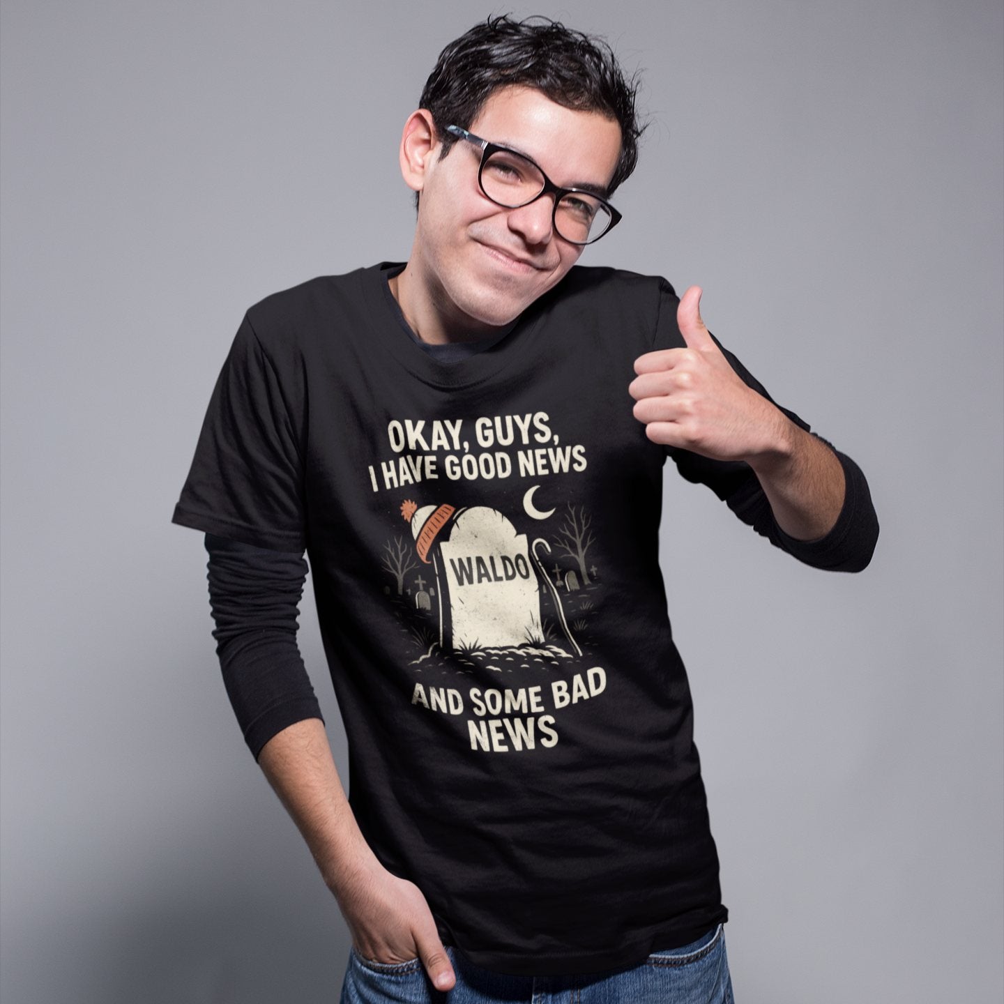 Model wearing black Waldo tombstone shirt with thumbs up and dark comedy theme