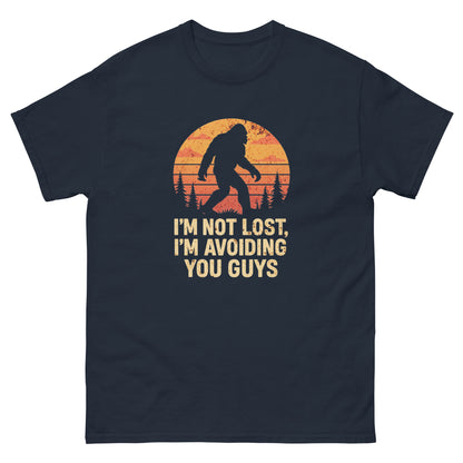 Navy blue outdoorsy bigfoot shirt featuring bold “avoiding you” slogan and trees