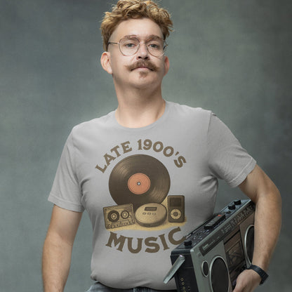 Man wearing retro “Late 1900s Music” t-shirt holding a cassette player, smiling ironically