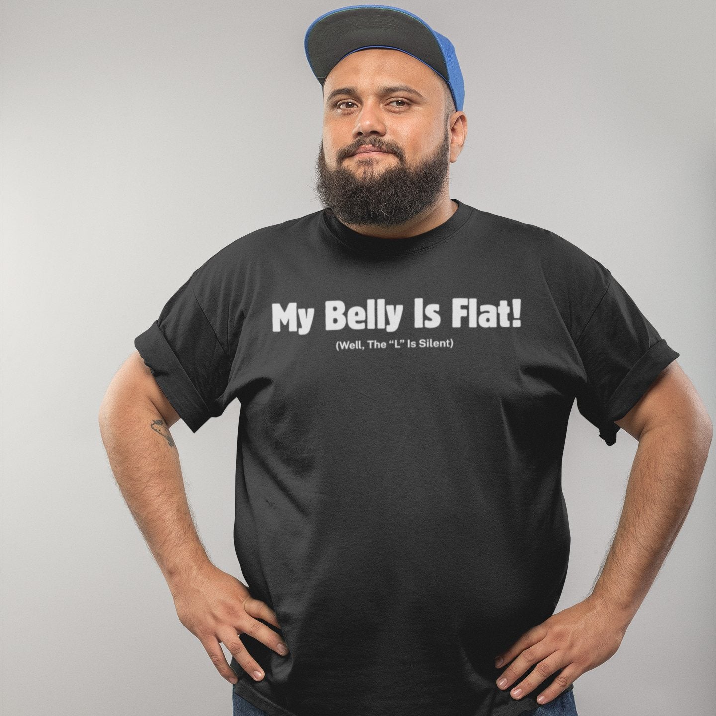 Man in black t-shirt and cap wearing funny belly humor tee with sarcastic slogan about being flat