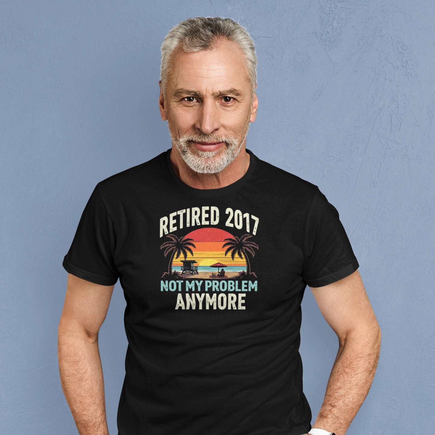 Smiling man wearing the “Retired 2017 Not My Problem Anymore” t-shirt with beach design, showing casual relaxed retirement vibe