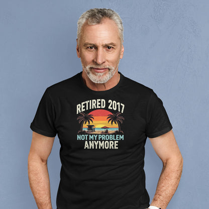 Smiling man wearing the “Retired 2017 Not My Problem Anymore” t-shirt with beach design, showing casual relaxed retirement vibe